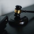 small judge gavel placed on table near folders